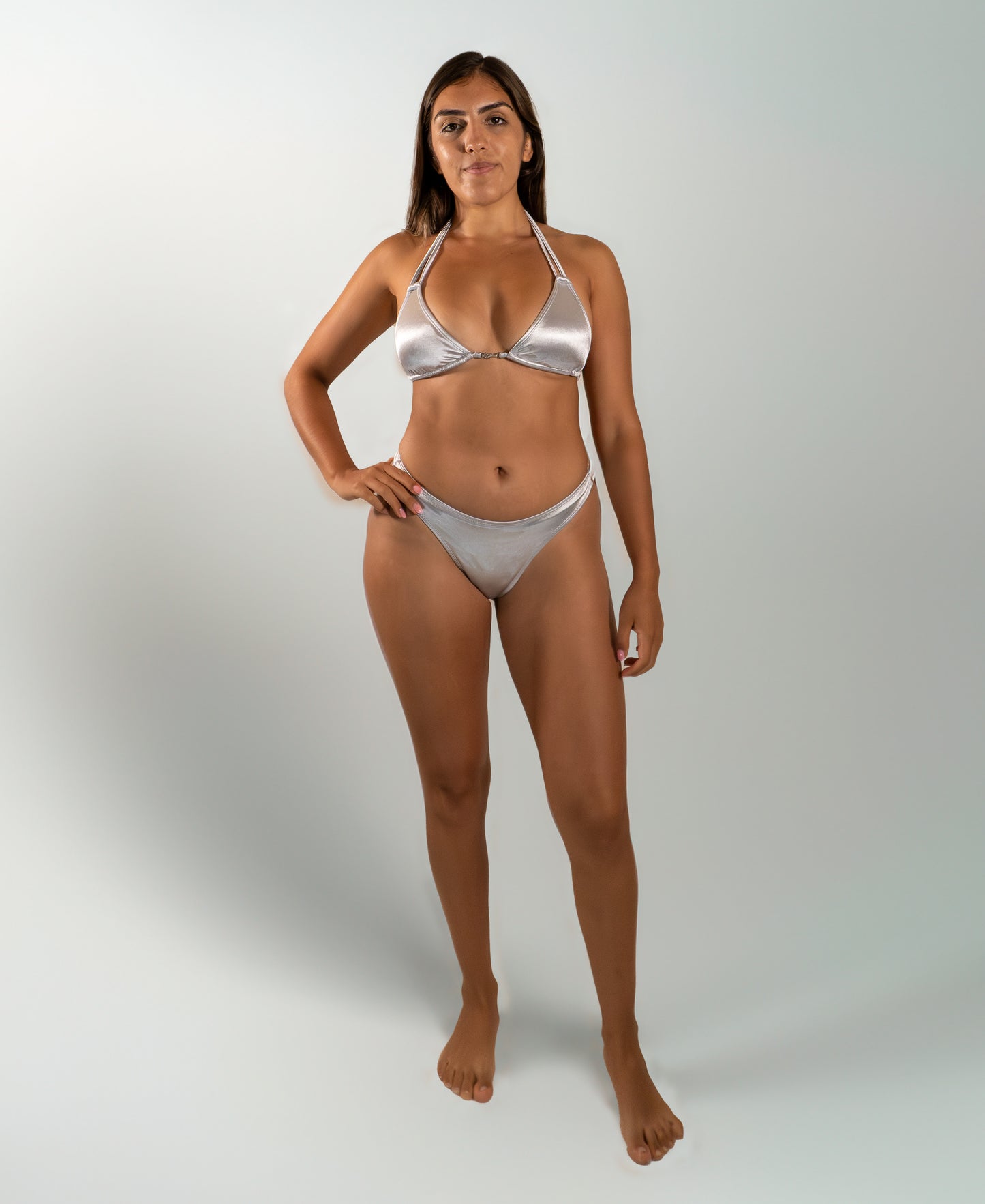 Model wearing the Estrella Swim Astra triangle bikini set in silver metallic satin, front view on white background.