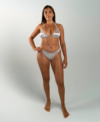 Model wearing the Estrella Swim Astra triangle bikini set in silver metallic satin, front view on white background.