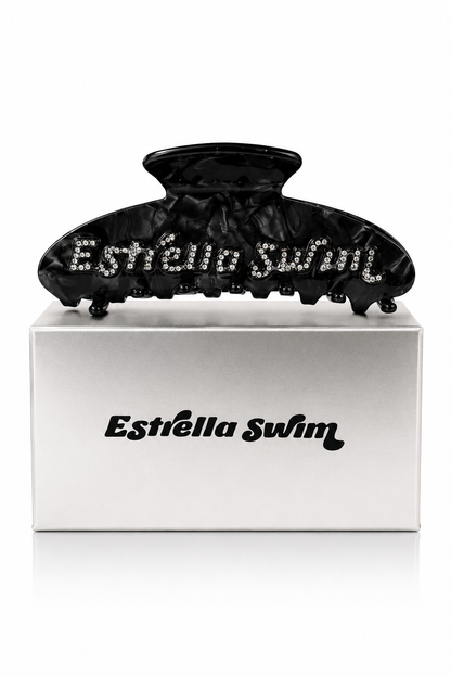 Estrella Swim black hair claw clip displayed on branded packaging box.