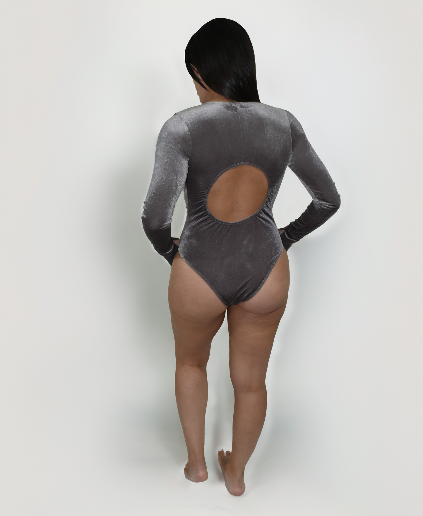 Model wearing the Estrella Swim Selena one-piece swimsuit in grey velvet, back view on white background.