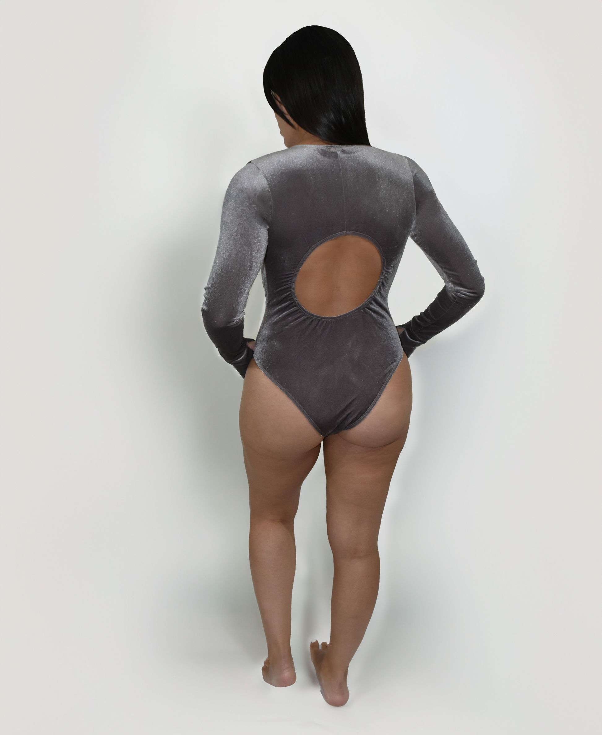 Model wearing the Estrella Swim Selena one-piece swimsuit in grey velvet, back view on white background.